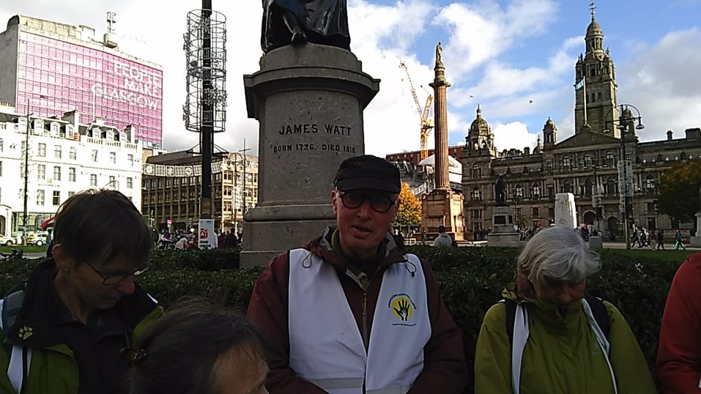 De deelnemers op het einde van hun toch bij het standbeeld van James Watt op George Square in Glasgow