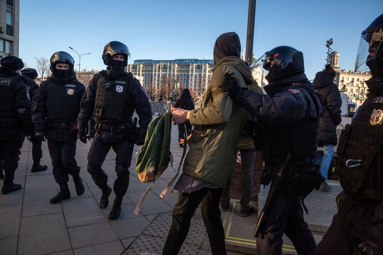 Russische politiemannen arresteren een vredesactivist op het Pushkinplein in Moskou op zondagmorgen 27 februari 2022