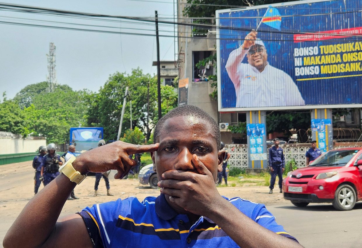 Een Congolese betoger in Kinshasa maakt op maandag 12 februari 2024 het symbolische gebaar om aandacht te vragen voor het ‘vergeten’ conflict in het oosten van het land (foto: Reuters).